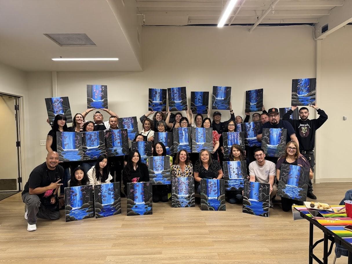 A large BiRite group holding up the waterfall paintings they made at their event