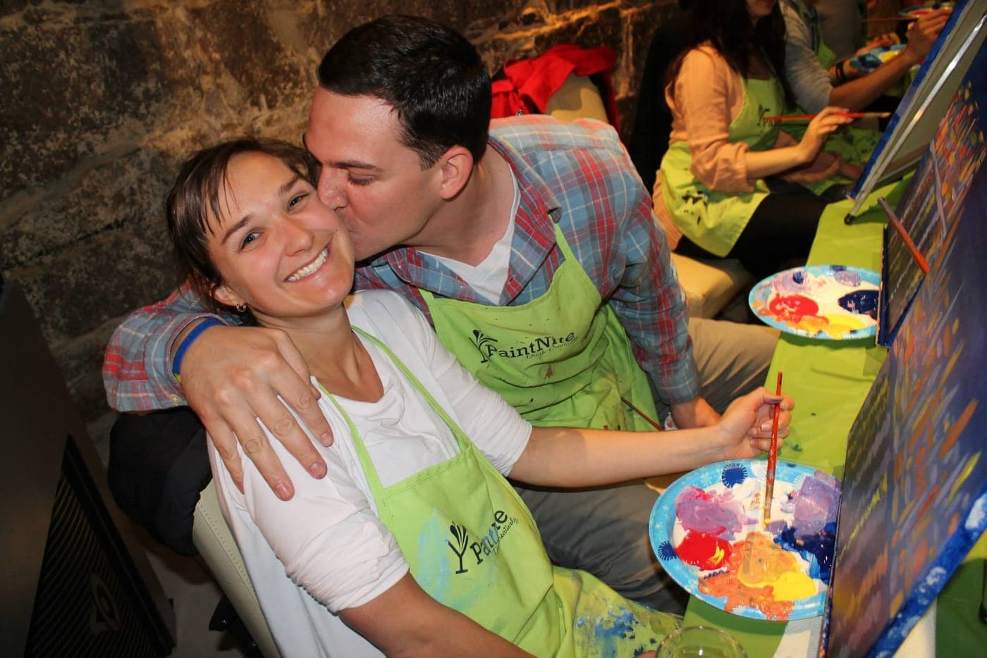 A couple painting together at a Paint Nite event