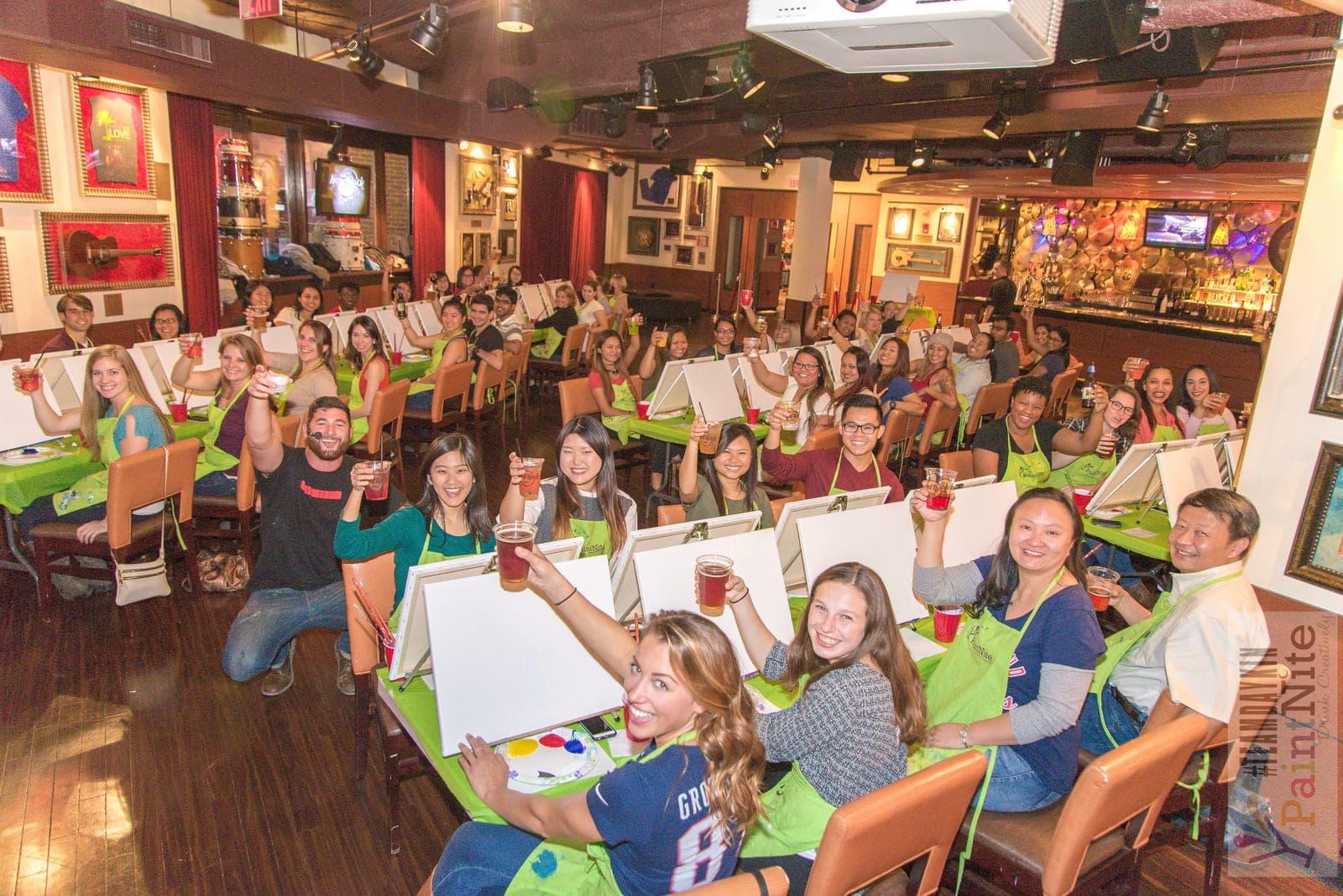 A Paint Nite host leading a lively painting class at a venue